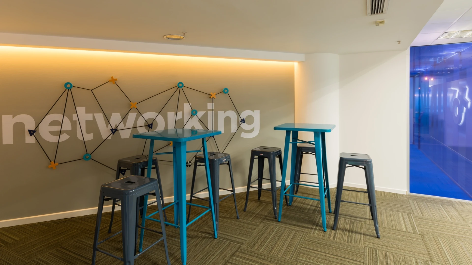Área de networking con mesas altas y banquetas