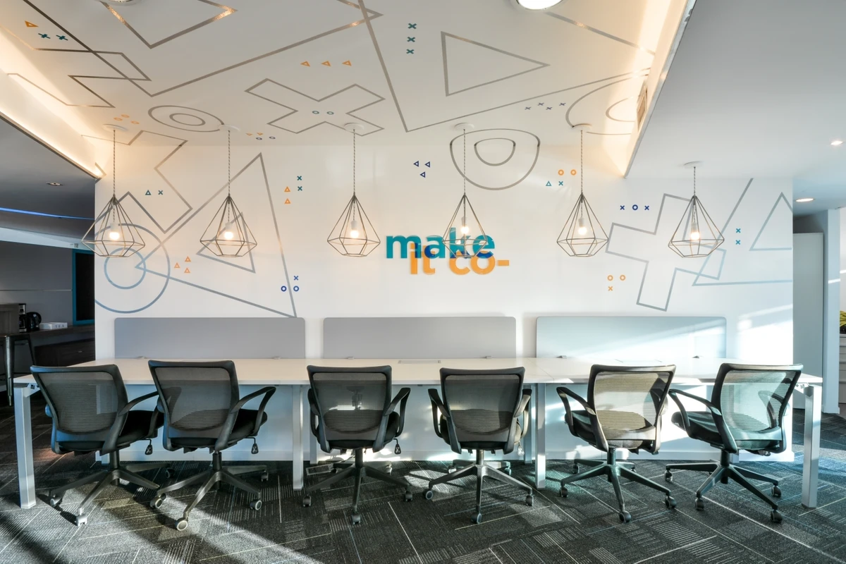 Espacio de coworking con mural 'make it co-'
