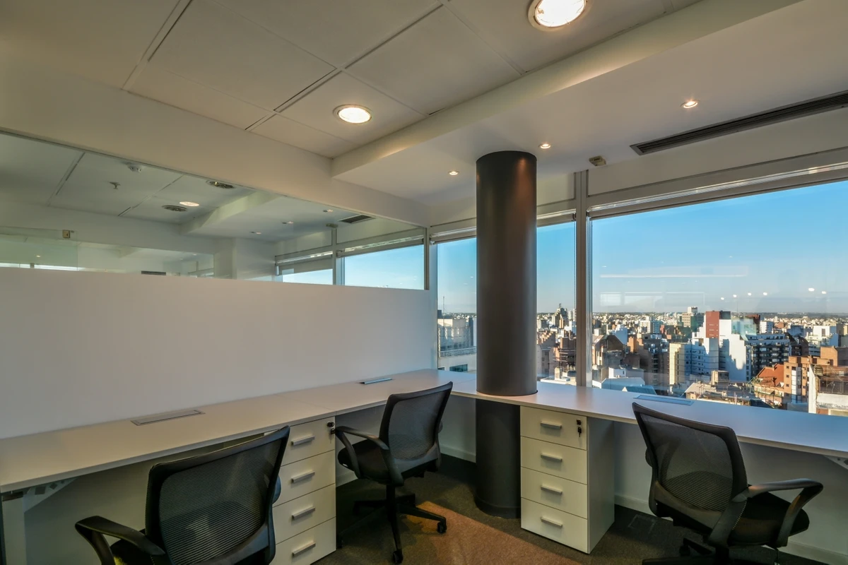Oficina privada con escritorios y vista a la ciudad