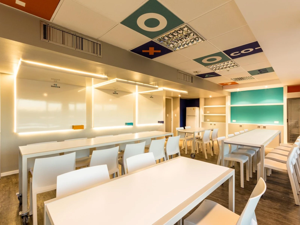 Aula de capacitaciones con pizarras y techo decorado